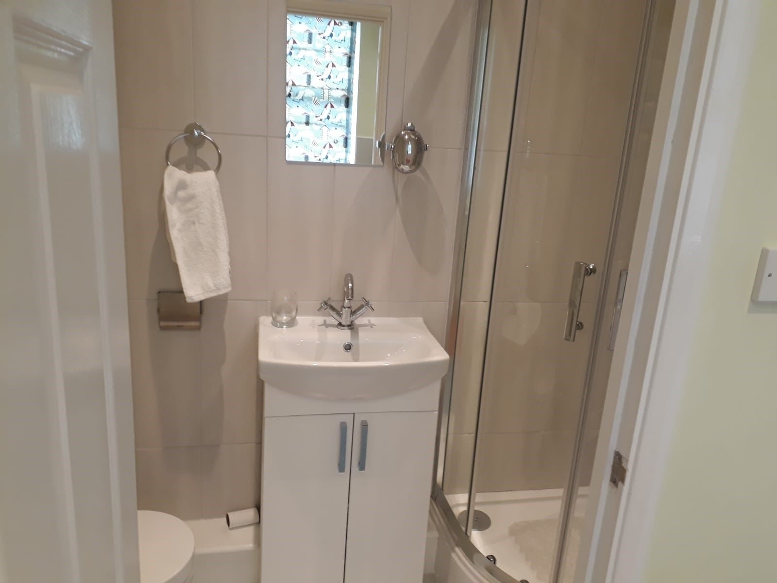 A bathroom with a white sink, a glass shower enclosure, and a toilet.