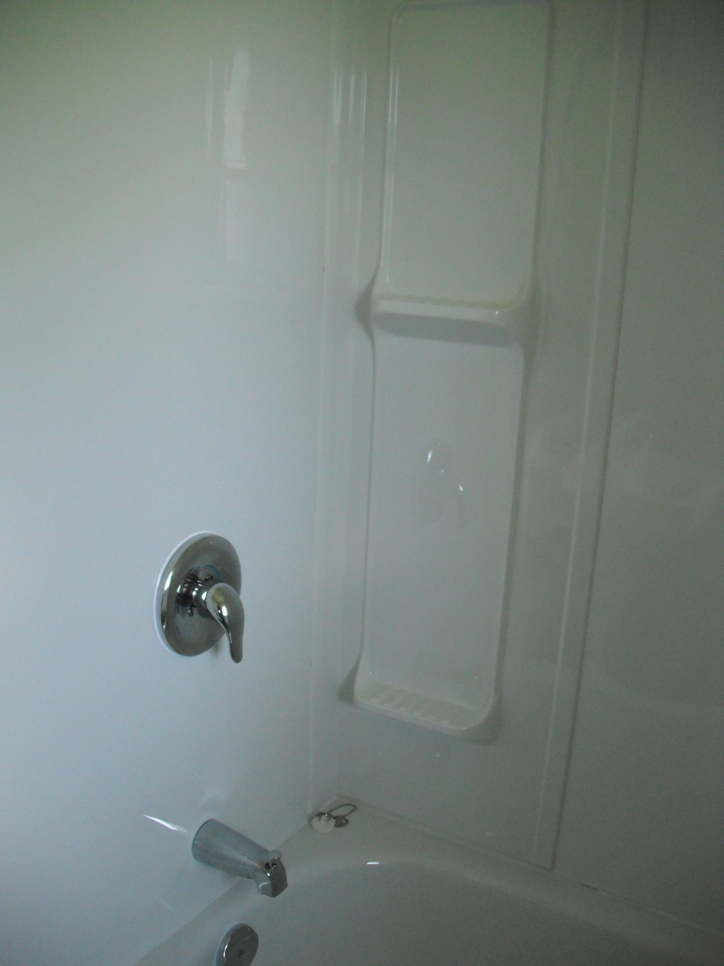 Un baño con bañera, grifo y cabezal de ducha.