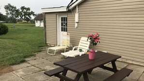 Ein Picknicktisch mit zwei Stühlen und einer Blumenvase.