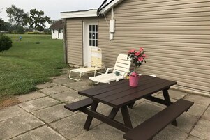 Una mesa de picnic con dos sillas y un florero.