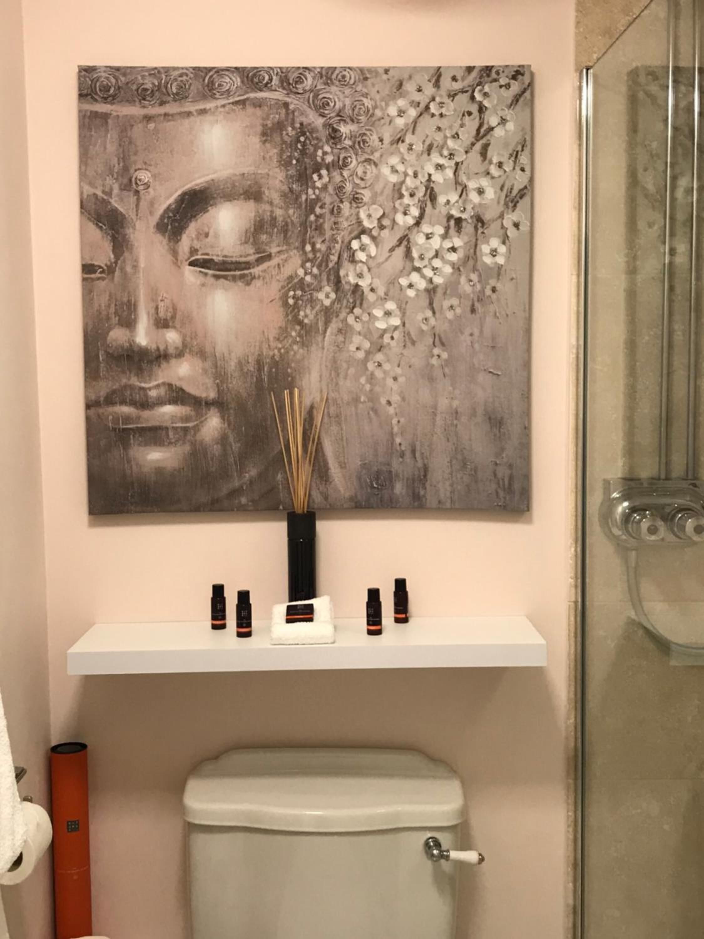 Un baño con inodoro, lavamanos y artículos de aseo, y ducha.