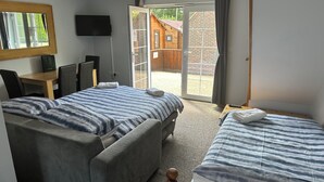 Un dormitorio con dos camas, un escritorio y una televisión.