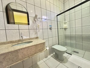A bathroom with a marble sink, a toilet, and a glass shower enclosure.