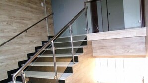 A modern staircase with metal railings and wooden steps. - Hotel Pousada Real (Sinop)