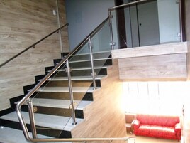 Una escalera moderna con barandillas de metal y peldaños de madera.