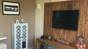 A living room with a wooden TV stand, a white cabinet, and a sofa.