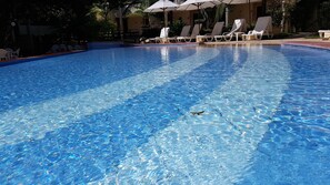 A clear swimming pool with lounge chairs and umbrellas. - Solar Pipa Apartamentos (Tibau do Sul)
