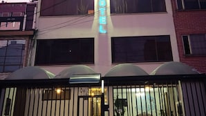 A hotel with a prominent neon sign, a gated entrance, and a modern architectural design. - Hotel Mont Bleu (Bogotá)