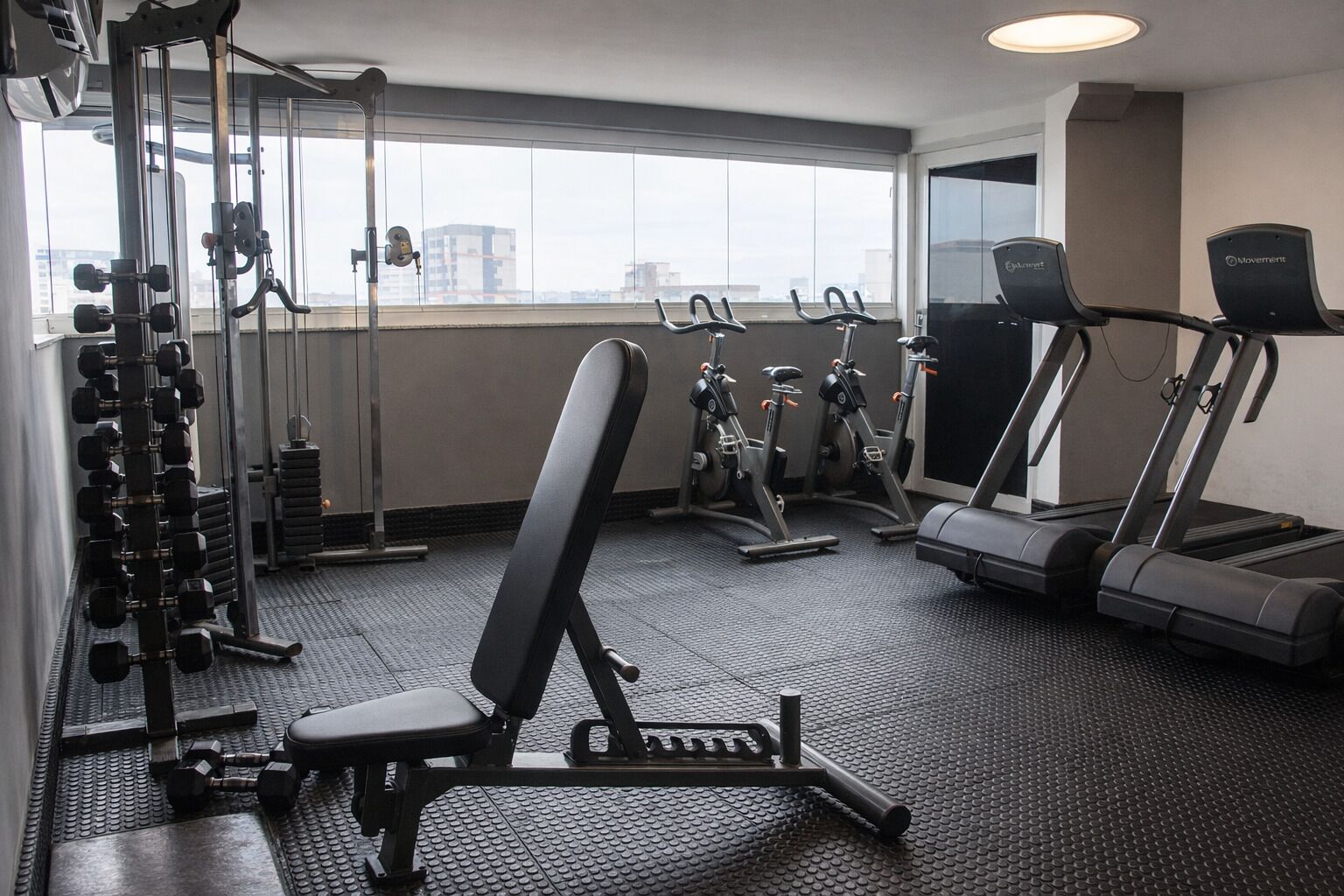 A gym with treadmills, stationary bikes, and free weights.