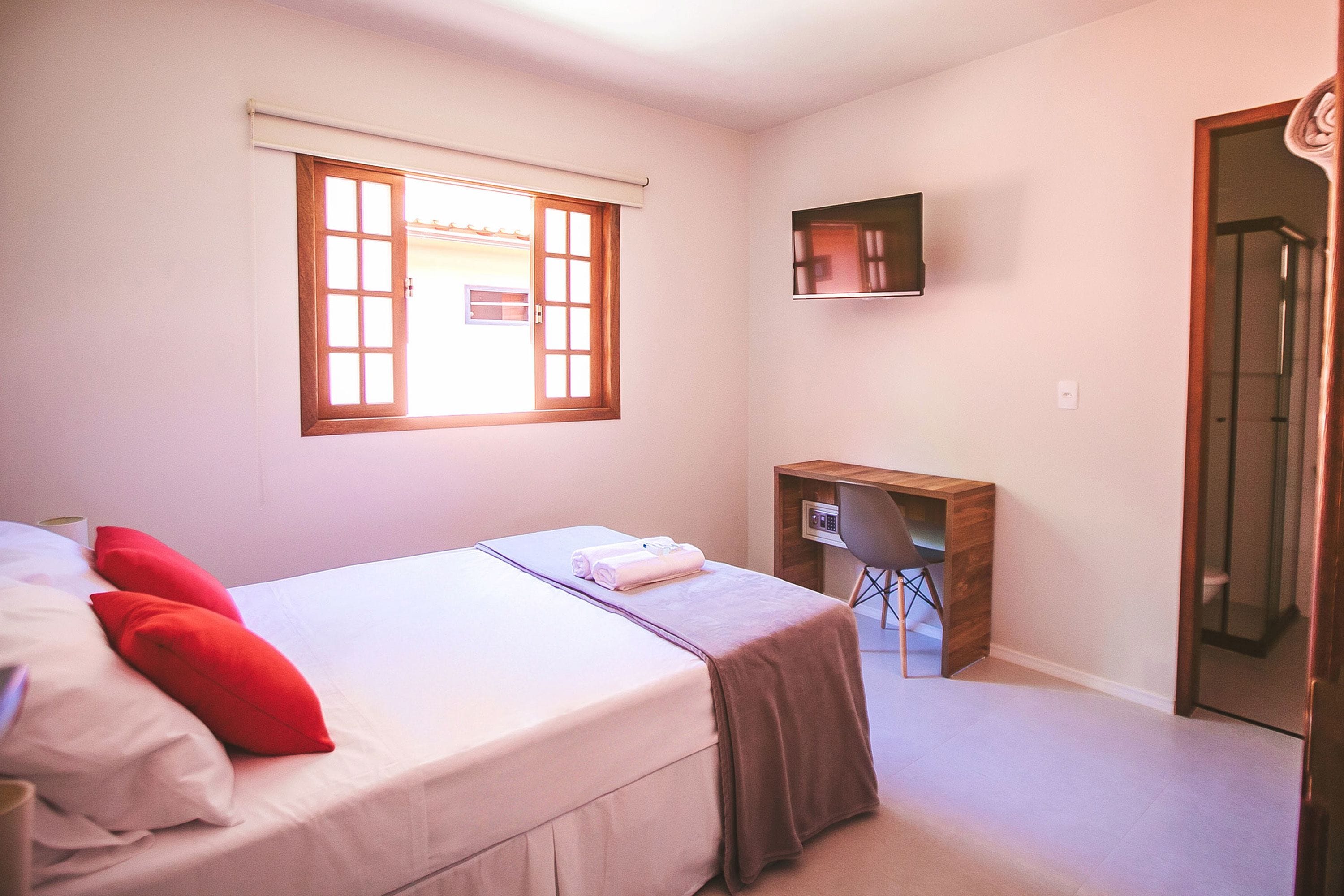 Un dormitorio con cama, escritorio y zona de ducha.