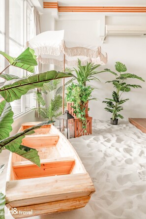 Quarto com um banco em forma de barco de madeira, parede branca e uma janela grande.