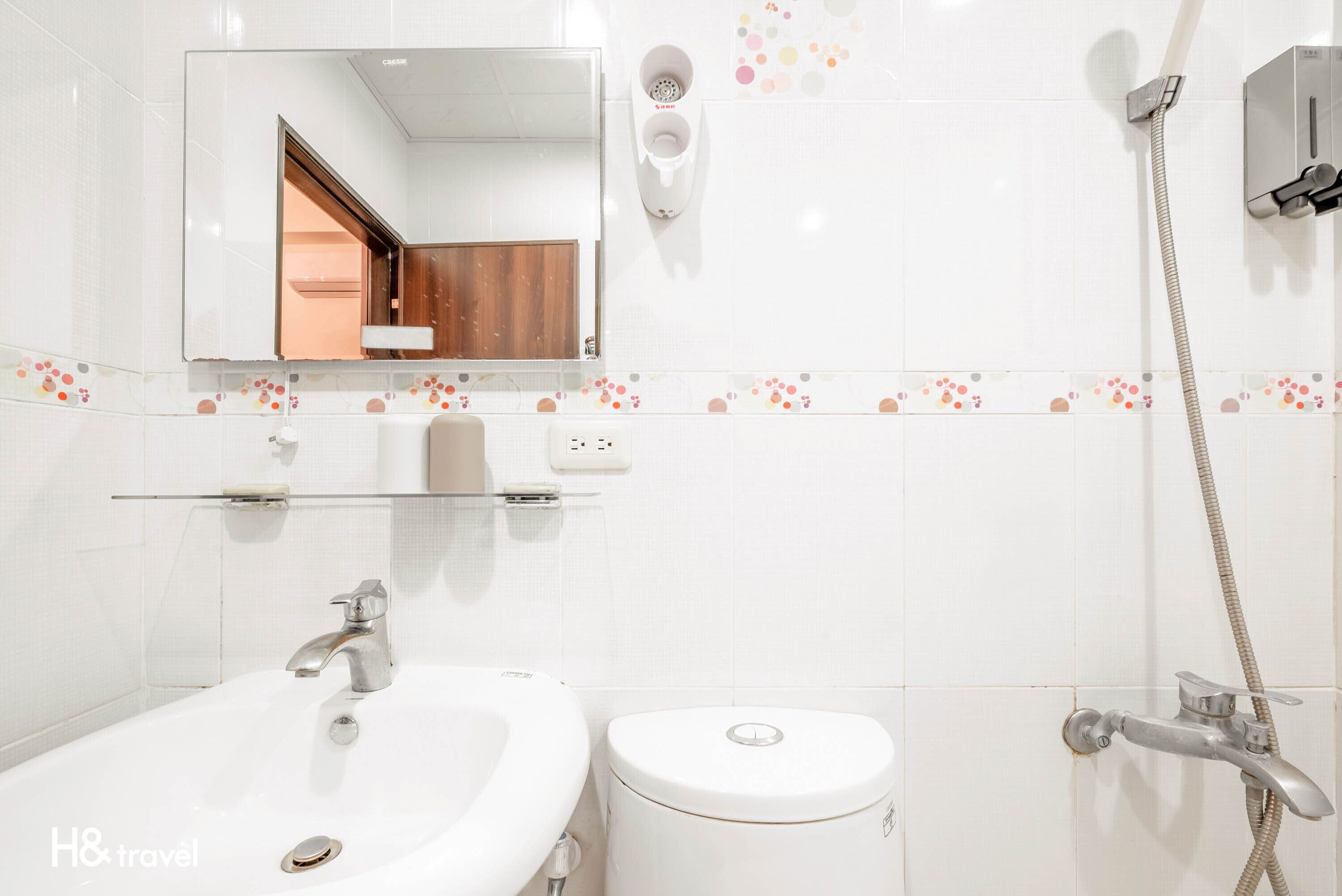 A modern bathroom with a sink, toilet, and shower.