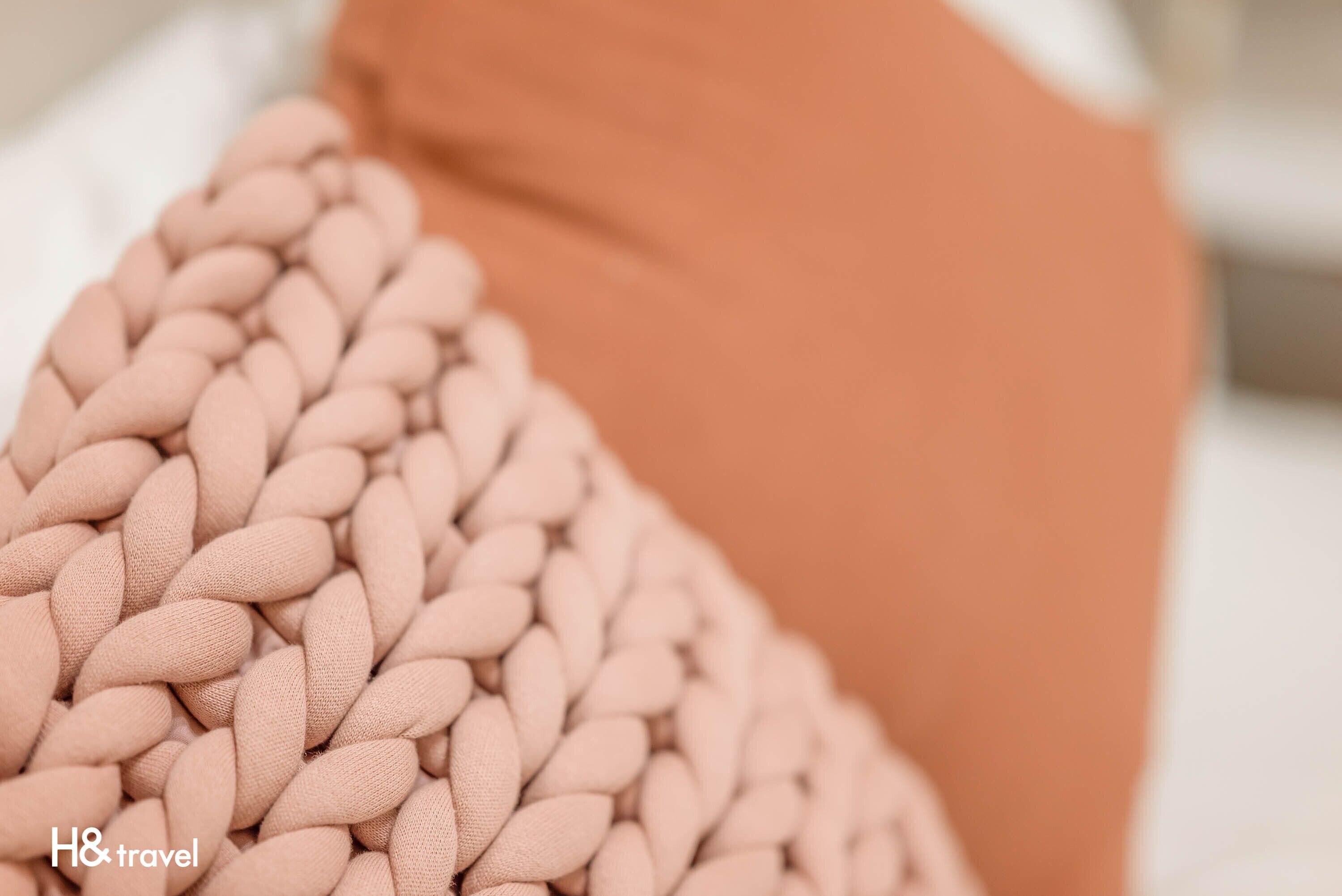 A close-up of a knitted throw blanket with a textured pattern.