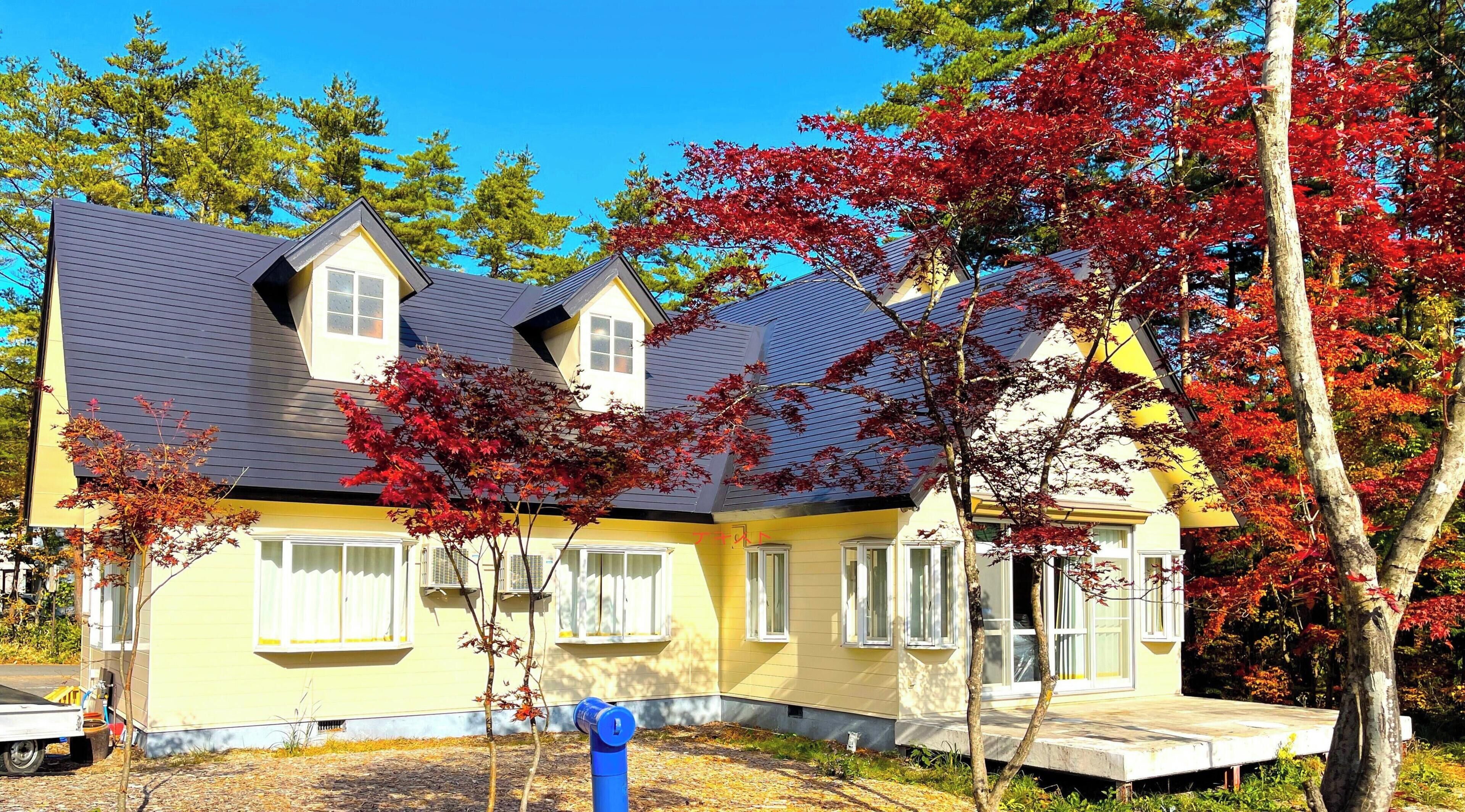 A two-story house with a grey roof and yellow siding.