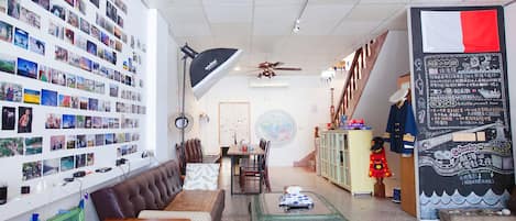 Un ambiente acogedor con una pared de fotos, un comedor y un pequeño escenario.