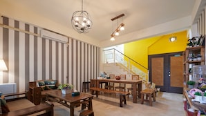 A spacious living area with a staircase leading to a bright yellow room. - Avenue B&B (Hualien City)