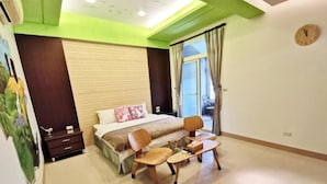 A bedroom with a bed, bedside tables, a desk with chairs, a window with curtains, and a clock on the wall. - Greenpark Homestay (Luodong)