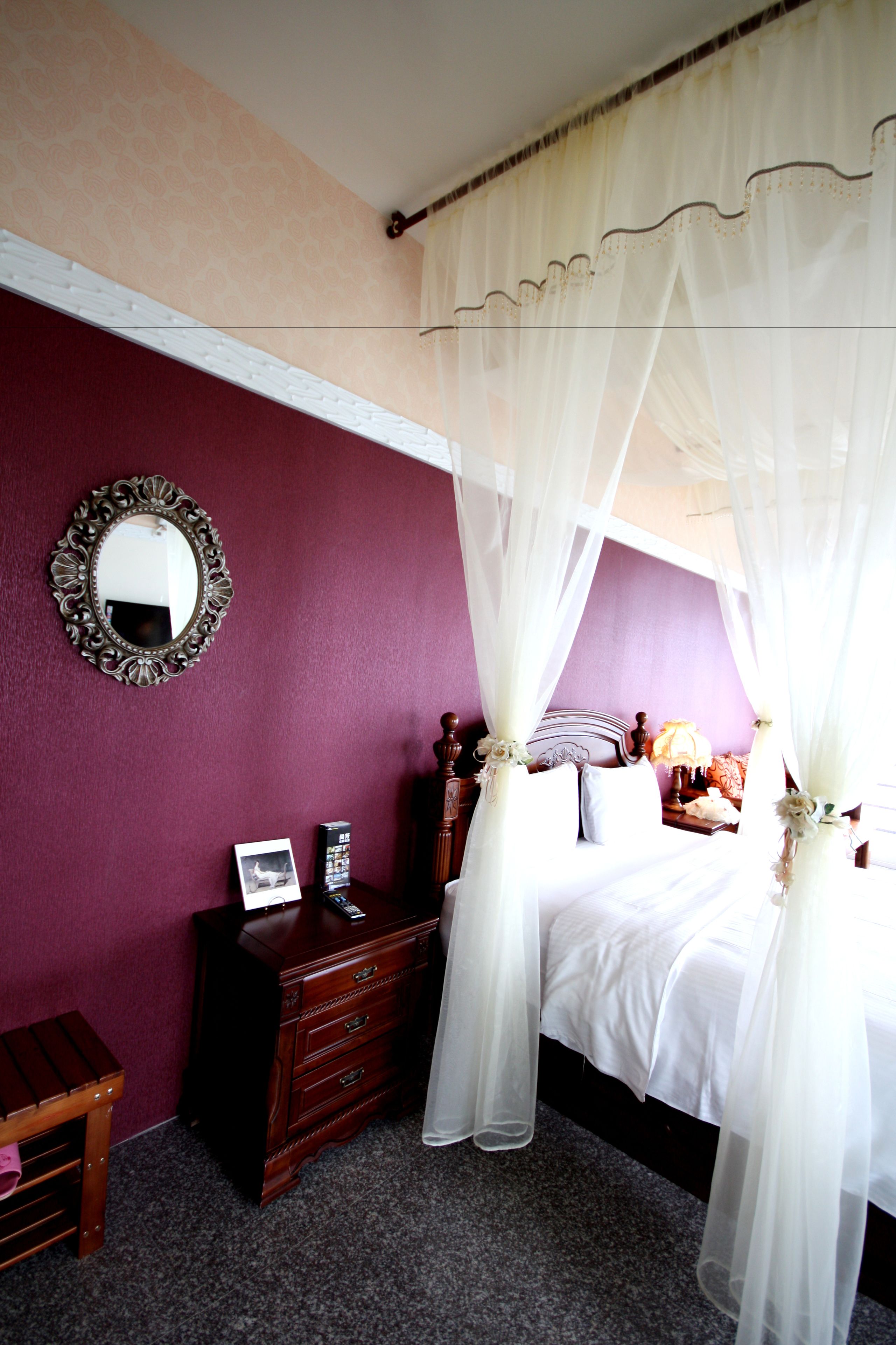 A bedroom with a bed, a dresser, a mirror, and a nightstand.