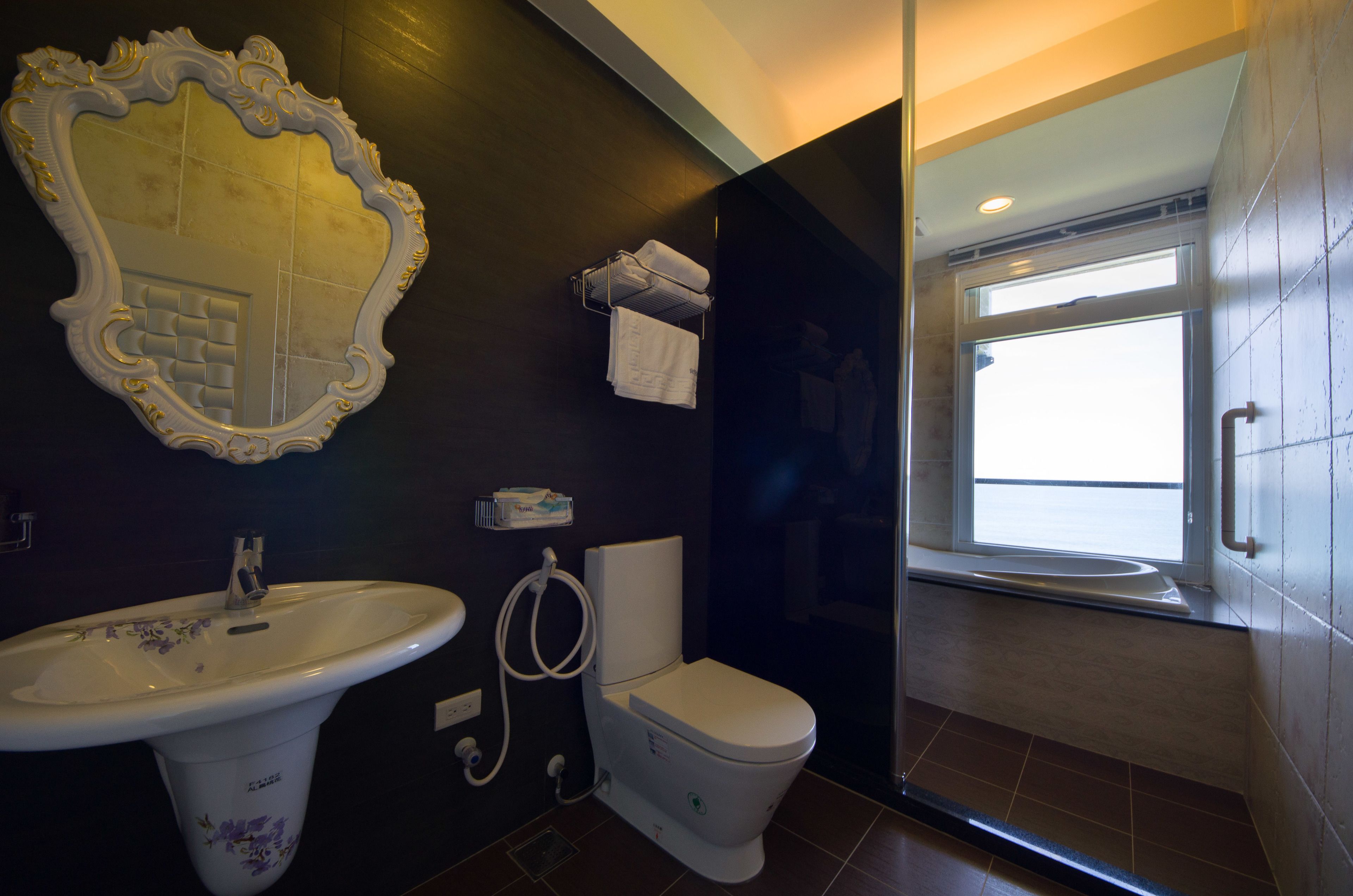 Un baño con lavamanos blanco, inodoro y un espejo grande.