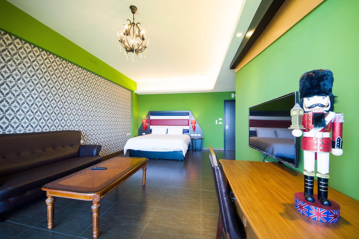 Una habitación de hotel con una cama, un sofá, una mesa de centro de madera, un televisor y una decoración de cascanueces.
