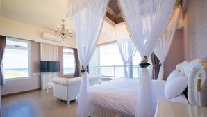 Un dormitorio con una cama grande, televisión y vistas al balcón.