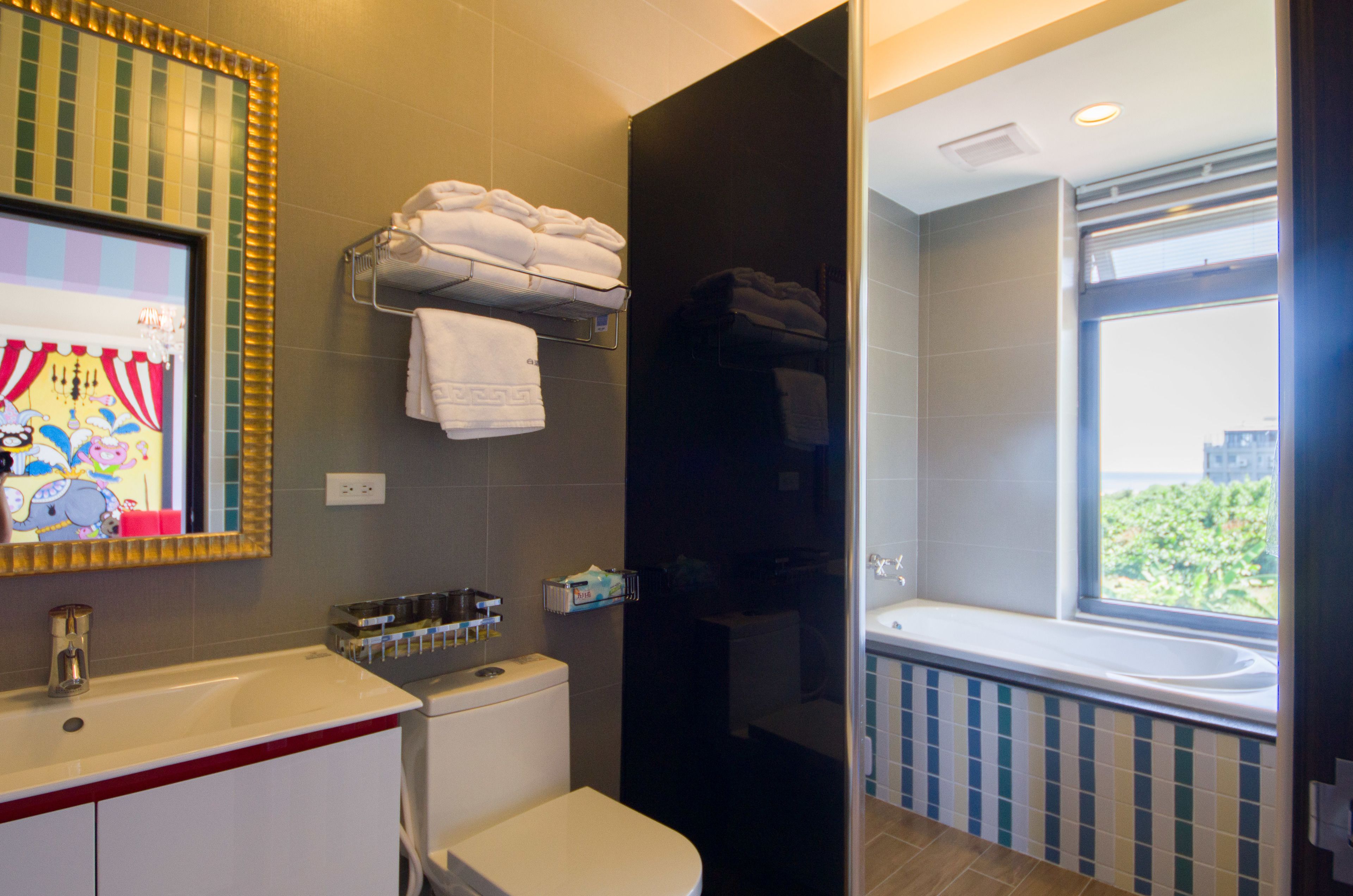 A modern bathroom with a toilet, sink, and a window with a view.
