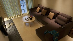 Uma sala de estar moderna com um sofá, uma mesa de centro e uma televisão.