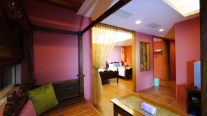 A room with a bed, a wooden bench, and a table with a lamp. - Dragon Resort of Hotel (Hengchun)