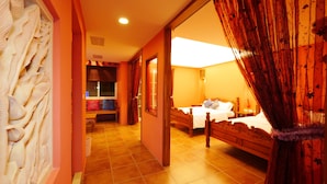 A hotel room with two beds, a sitting area with a bench, and a view of the outside. - Dragon Resort of Hotel (Hengchun)
