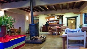 Un interior acogedor con barra, muebles de madera y chimenea.