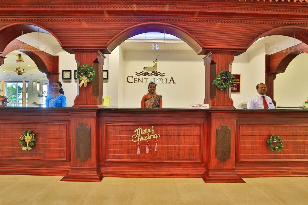 A reception desk with a 'Merry Christmas' sign, a logo for Centauria, and a 'No Smoking Area' sign.