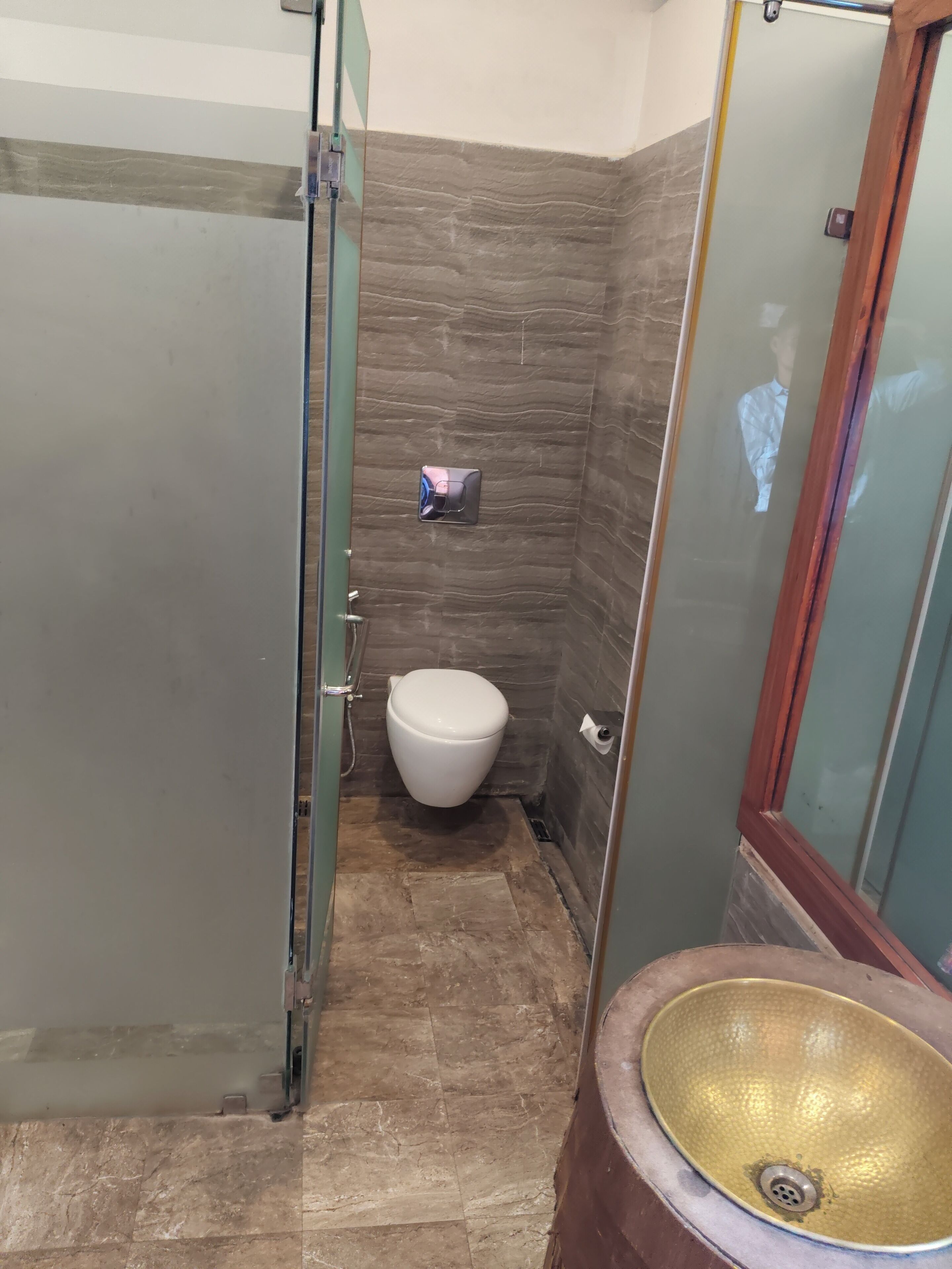 Un baño con inodoro, lavamanos y zona de ducha.