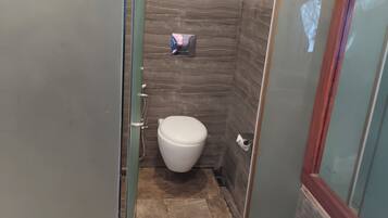 Un baño con inodoro, lavamanos y zona de ducha.