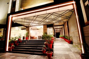 A hotel entrance with a modern design, featuring a geometric ceiling pattern, a series of steps leading up to the entrance, and potted plants lining the pathway. - Pinnacle by Click Hotels, Lucknow (Lucknow)