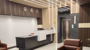 A modern reception area with a reception desk, seating, and a decorative wall. - Pinnacle by Click Hotels, Lucknow (Lucknow)