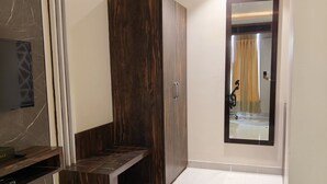 A modern room with a dark wood wardrobe, a built-in TV, and a mirror with a curtain. - Pinnacle by Click Hotels, Lucknow (Lucknow)