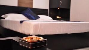 Une chambre moderne avec un cadre de lit noir, du linge de lit blanc et un oreiller bleu.