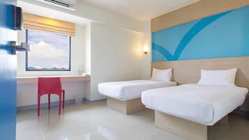 A hotel room with two beds, a desk, a chair, an air conditioning unit, and a window with a view.