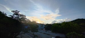 A parking lot with trees and buildings in the background. - Yuu-lee Casa Bendita Huatulco (Santa María Huatulco)