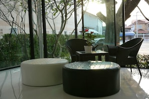 A modern room with a glass table, two chairs, and a potted plant.