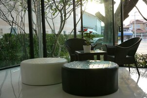 Una habitación moderna con una mesa de vidrio, dos sillas y una planta en maceta.