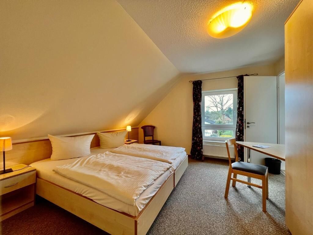 Ein Schlafzimmer mit zwei Betten, einem Schreibtisch und einem Stuhl.