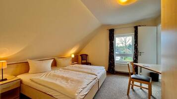 Ein Schlafzimmer mit zwei Betten, einem Schreibtisch und einem Stuhl.
