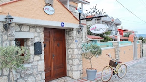 Un edificio con fachada de piedra, puerta de madera y un letrero que dice "Villamer".