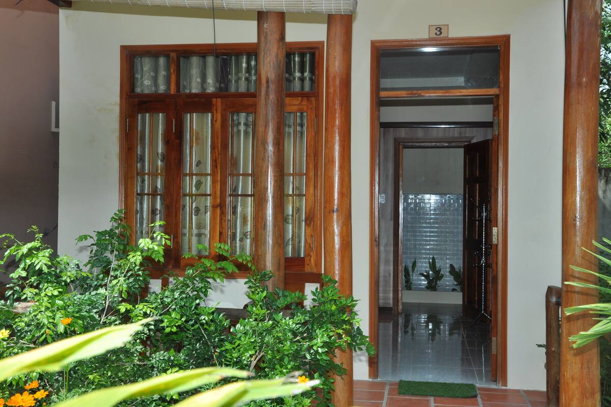 A wooden door with glass panels, a tiled entrance, and a green mat.