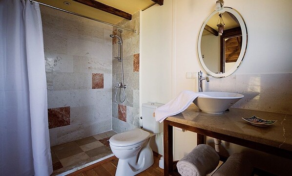 A bathroom with a shower, toilet, sink, and mirror.