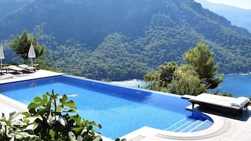 Relax by the pool surrounded by lush greenery and breathtaking mountain views.
