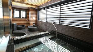 Un área de spa moderna con suelo de piedra, paneles de madera y un ventanal con persianas.