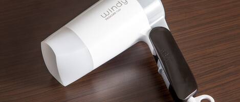 Un sèche-cheveux portable noir et blanc, doté d’un design compact, posé sur une surface en bois.