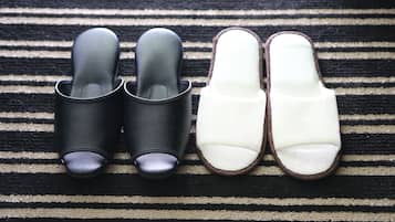 A pair of black and white slippers on a striped rug.